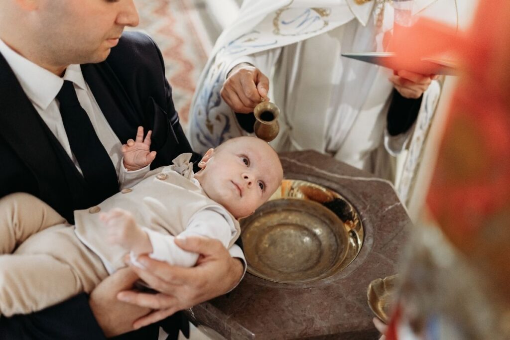 Niemowlę podczas ceremonii chrztu świętego - ksiądz polewa głowę dziecka wodą chrzcielną - reportaż chrztu Warszawa - Magda Zaborowska Fotografia